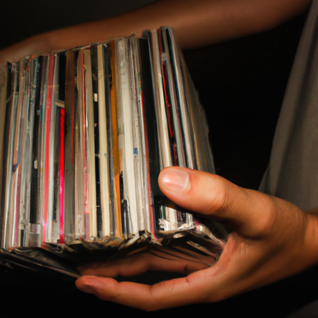 Person holding music album collection